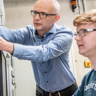 Ein Dozent und ein Student an einer technischen Anlage